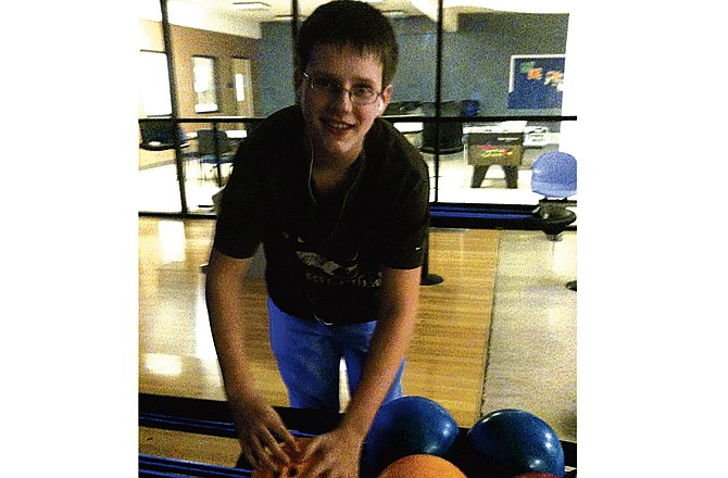 Kaleb Keep, 15, of St. Martins, picks out a bowling ball during a game at the Lincoln University bowling center Saturday night. Keep played with his friend, Rory Clay, 13, of Holts Summit as part of a bowling night organized by the Jefferson City Suicide Prevention Coalition.Â 
