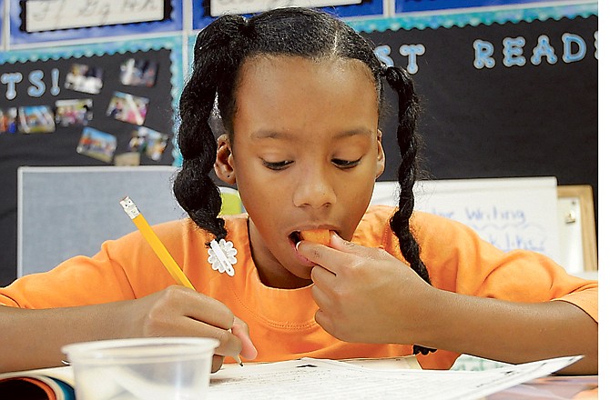 Page Newsome avails herself of a healthy afternoon snack as she works on a project at South Elementary School. She is a fourth-grade student in Angie Clark's classroom.