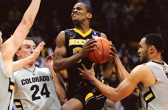 Kim English of Missouri drives between Colorado teammates Levi Knutson (24) and Marcus Relphorde (5) during Saturday's game in Boulder, Colo.