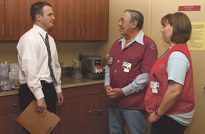 Nathan Witt, left, voluntary service officer with the Harry S Truman Memorial Veterans' Hospital in Columbia, Mo., visits with volunteers Charlie Smith and Devon Smith.