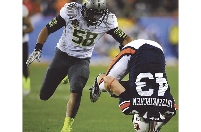 Auburn's Philip Lutzenkirchen (43) tumbles after making a catch as Oregon's Kenny Rowe defends during the second half of the BCS National Championship NCAA college football game Monday, Jan. 10, 2011, in Glendale, Ariz. 