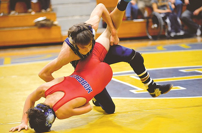 
Ryan Mankin of Helias takes down Nick Kelly of Moberly in the 112-pound match during Thursday night's dual at Rackers Fieldhouse. To view this and other photographs, please visit www.newstribune.com/photos.