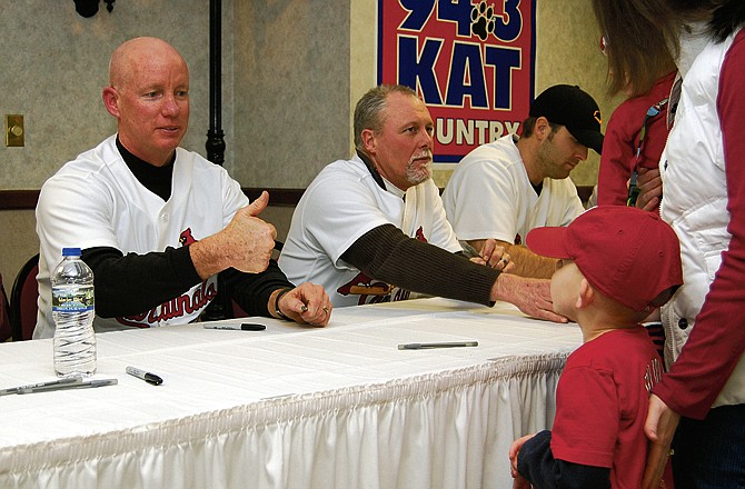 Former Cardinal pitcher John Costello greets a young fan during Saturday evening's Cardinal Caravan. 