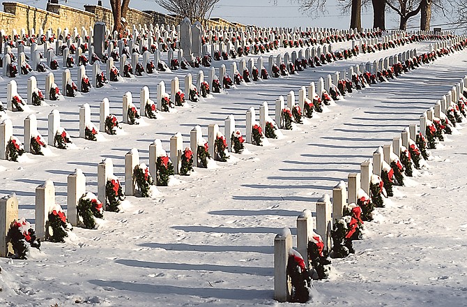 Morning shadows are cast in the snow which highlights the wreaths at headstones in National Cemetery in Jefferson City. They will be removed and put in storage Saturday, and the fundraising committee is asking for help to pick them up.