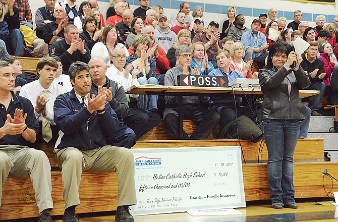 Audience members applaud an address by Karen Scott just before representatives from American Family Insurance presented Helias High School with a $15,000 check for winning one of the Teen Safe Driver Pledge Program awards Tuesday evening at Rackers Fieldhouse. Helias logged the most participants in their school size division. A school in Colorado and a school in Arizona also won top prizes.