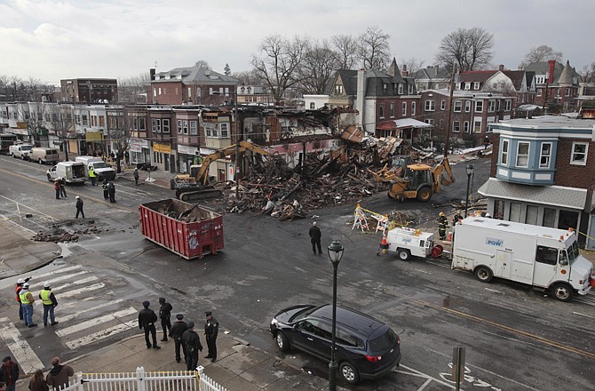 Crews remove debris from the site of a gas main explosion in Philadelphia on Wednesday. The gas main explosion sent a 50-foot fireball into the sky above a Philadelphia neighborhood, killing a utility worker, injuring six other people and forcing dozens of residents from their homes. 