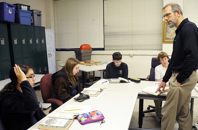 Annie Donovan, left, raises her hand to answer a question posed by Mark Rehagen, who teaches Latin to students who voluntarily arrive an hour early before the start of the regular school day. Next to Donovan and around the table are Mariah Messenger, Michael Ginther and Nick Hafner, who are are seventh- and eighth-grade students at St. Joseph Cathedral School. 