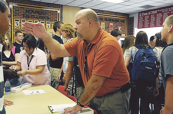 Lou Mazzocco directs JCHS sophomore students as they wait to pick up their photo identification cards at the beginning of the 2010-11 school year. School district officials are studying the demographics of Jefferson City as the student population continues to grow. 