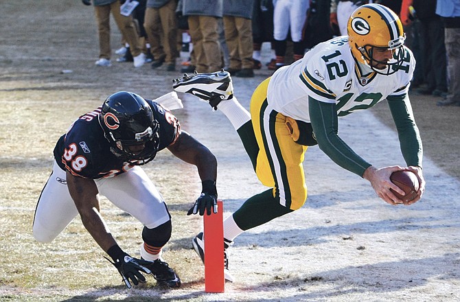 Packers quarterback Aaron Rodgers dives into the end zone past Bears safety Danieal Manning during Sunday's game in Chicago. 