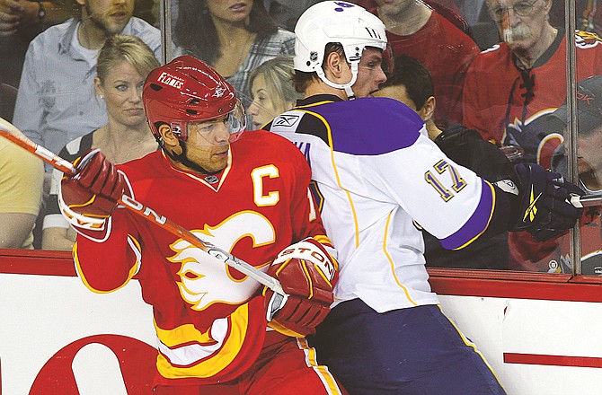 Vladimir Sobotka of the Blues gets checked into the boards by the Flames' Jarome Iginla during the first period of Wednesday night's game in Calgary, Alberta.