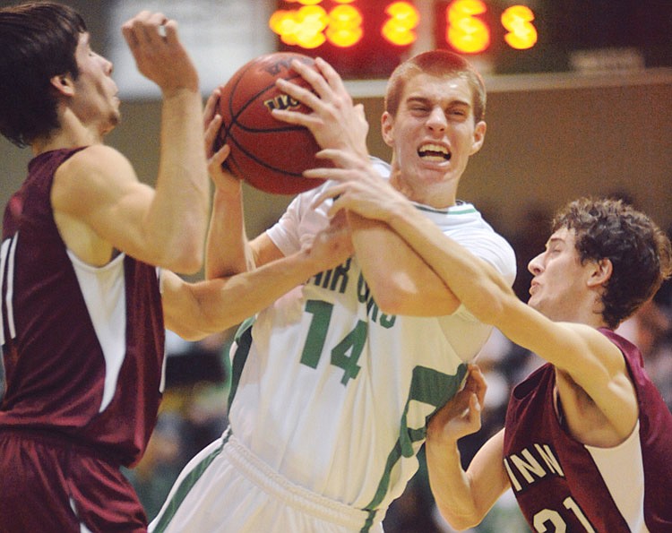 Brandon Moore, (14), drives past two Linn Wildcat defenders during the first half Friday, Jan. 28, 2011, in Wardsville.