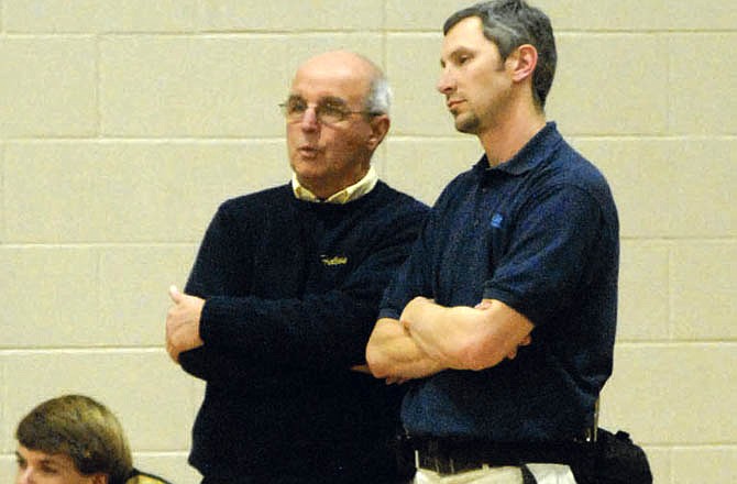 Stan Ochsner (left) talks with athletic trainer Ben Kuster during a Helias girls basketball game last week at Rackers Fieldhouse.