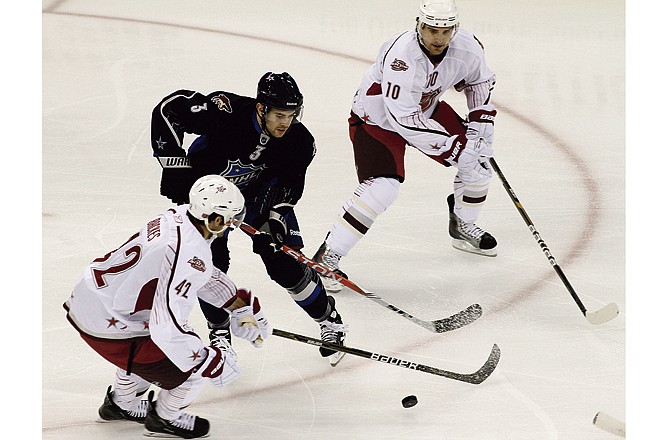 Team Staal's Patrick Sharp (10), of the Chicago Blackhawks, and David Backes (42), of the St. Louis Blues, work for the puck with Team Lidstrom's Keith Yandle, of the Phoenix Coyotes, during the third period of hockey's NHL All-Star Game on Sunday, Jan. 30, 2011, in Raleigh, N.C. 