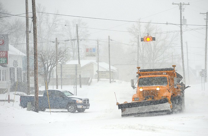 A Missouri Department of Transportation truck plows north on U.S. 63 at the intersection of Missouri 42 as heavy snow falls Tuesday morning, Feb. 1, 2011, in Vienna.