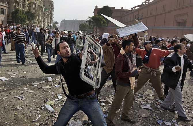 Anti-government protestors throw stones Thursday during clashes in Cairo, Egypt. Egypt's prime minister apologized for an attack by government supporters on protesters in a surprising show of contrition Thursday, and the government offered more concessions to try to calm the wave of demonstrations.