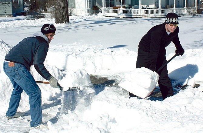 Colby Davis (left) and Hogan Davis shovel snow from sidewalks on Seventh Street in Fulton on Thursday. The Westminster College students are members of Delta Tau Delta. The fraternity members decided to help out their neighbors.