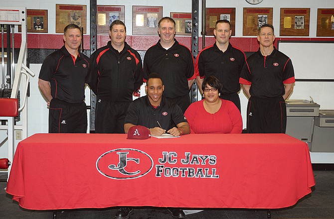 Jefferson City running back Kody Walker (seated, left) has signed a letter of intent to play for the Arkansas Razorbacks. Seated with Walker is his mother, Twila Walker. Standing are (from left) Jefferson City head coach Ted LePage and Jays assistants Mike Hall, Barry Blank, Chad Rizner and Kirk Obermiller.