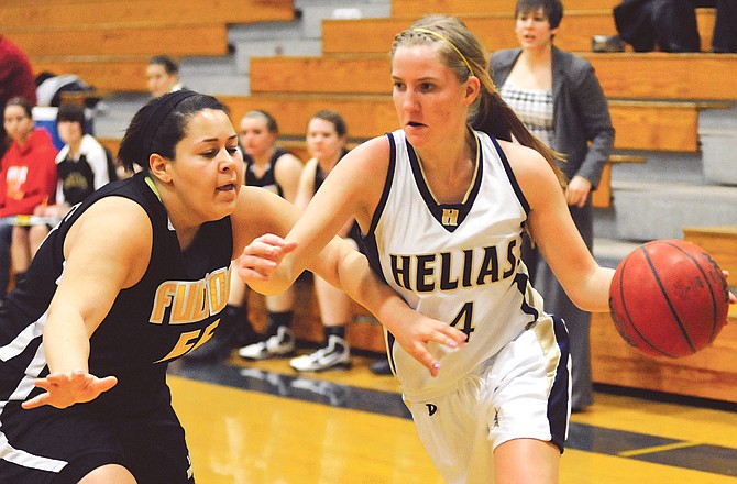 Alex Heislen of Helias tries to dribble around Meghan Davis of Fulton during Monday night's game at Rackers Fieldhouse.