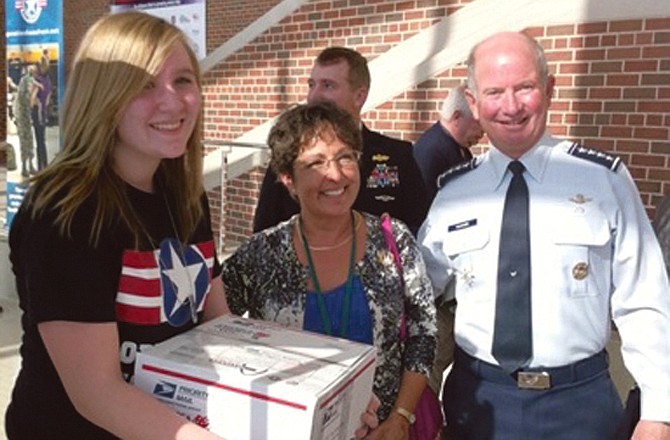 Emily Hulberg, Missouri National Guard's Teen Leadership Council, helps Gen. Duncan J. McNabb and his wife with their package for Operation Homefront. McNabb is the commander of the U.S. Transportation Command at  Scott Air Force Base, Ill.