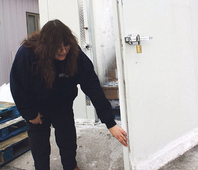Mandi Steele/FULTON SUN photo: Callaway Action Network Director Julie Roark points out damage done when someone tried to force open the door of SERVE, Inc.'s walk-in freezer over the weekend. Although the break-in was unsuccessful, the door will need to be replaced, at a cost of $3,741.