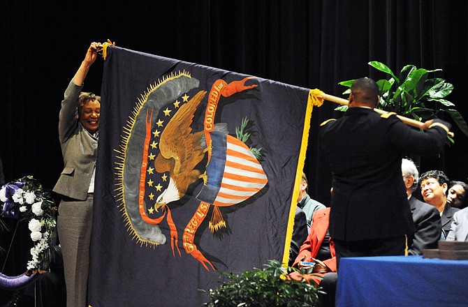 Lt. Col. Patrick Kent and Lincoln University President Carolyn Mahoney unveil a replica of the flag used by the colored infantry soldiers who used their pay to found Lincoln University. The flag was presented during the Founders Convocation on Thursday at Mitchell Auditorium in Richardson Fine Arts Center.