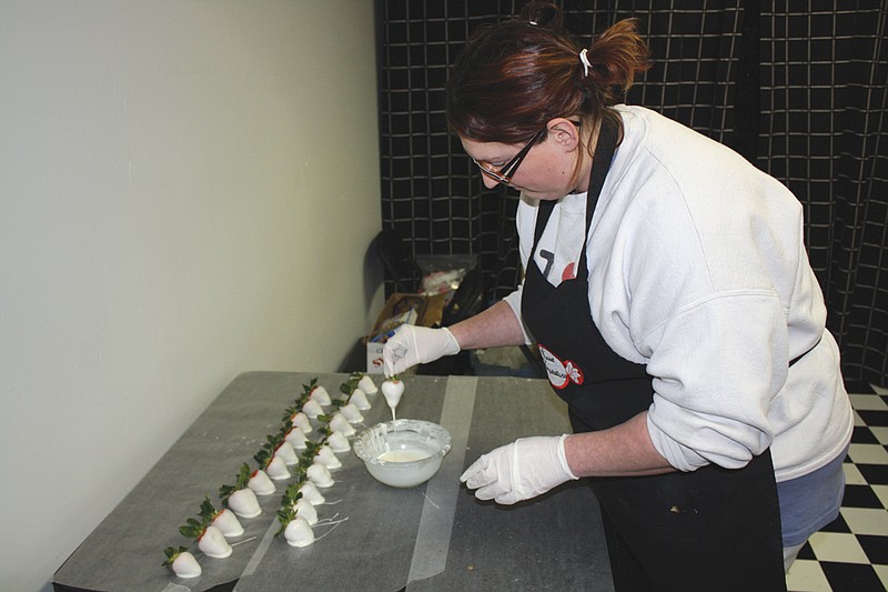Mandi Steele/FULTON SUN: Melanie Branch dips strawberries in white chocolate at Sweet Temptations on Thursday in preparation for Valentine's Day.