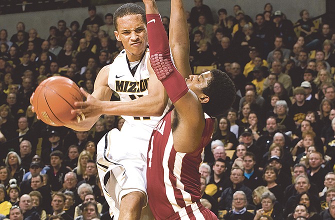 Missouri's Michael Dixon, left, is fouled by Oklahoma's Carl Blair, right, as he shoots during the second half of an NCAA college basketball game Saturday, Feb. 12, 2011, in Columbia, Mo. Dixon had a team-high 16 points in the game. Missouri won the game 84-61. 