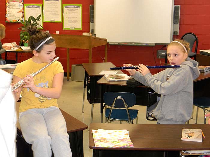 Fifth and sixth grade students in Paula Koerner's class, Olivia Percival, left, and Ally Harris, right, prepare a flute background to a class rap which competed with the third and fourth grade class rap at the first High Point basketball game held Jan. 27.