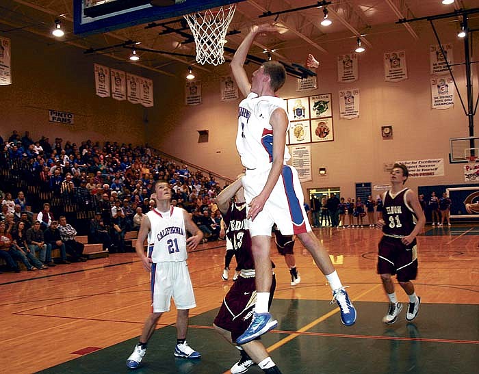 Phillip Longan is fouled while attempting a basket during the first quarter of California's Courtwarming game against Eldon. At left is California's Aaron Jones and at right is Eldon's John Hall (31).