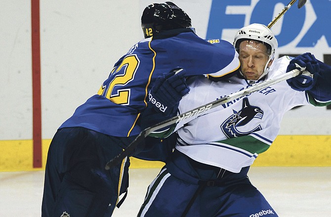 St. Louis Blues' David Backes (42) gets a roughing penalty for hitting Vancouver Canucks' Jannik Hansen, right, of Denmark, in the second period of an NHL hockey game Monday, Feb. 14, 2011, in St. Louis.The Blues won 3-2. 