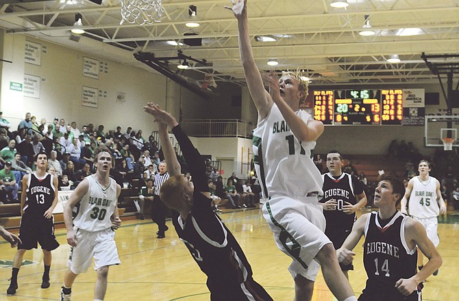 
Kellen Brondel (11) of Blair Oaks puts up a shot over Cody Shaw (3) of Eugene during the second quarter of Tuesday's game in Wardsville. Hayden Engelbrecht (14) of Eugene follows on the play. 