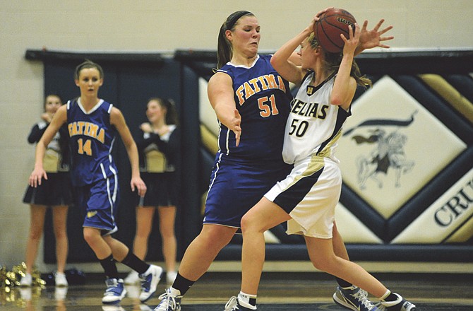 Elizabeth Grothoff of Helias looks to pass the ball as Lauren Allen of Fatima defends during Tuesday night's game at Rackers Fieldhouse. 