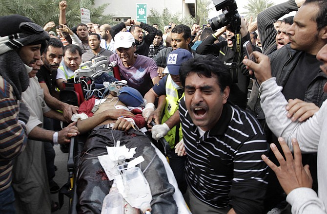 A Bahraini anti-government demonstrator lies injured on a stretcher early Thursday morning as other protesters take him to the hospital in Manama, Bahrain. Armed patrols prowled neighborhoods and tanks appeared in the streets for the first time Thursday after riot police with tear gas and clubs drove protesters from a main square where they had demanded sweeping political change in the tiny kingdom. 