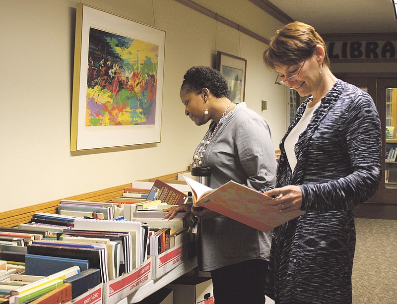 Don Norfleet/FULTON SUN photo: Ronesha Walker (left) and Katricia Pierson browse through books donated to the annual Fall in Love with Good Book Sale Wednesday at the William Woods University Library.