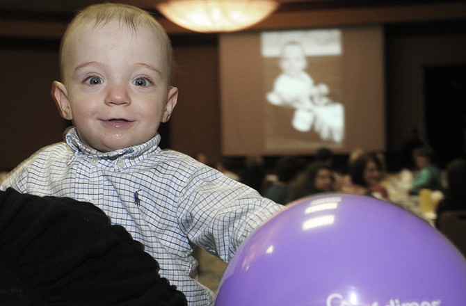 Ty Brandt, 1, is held by his aunt at the back of the room as his parents, Joyce and Danny Brandt, tell about his premature birth and subsequent hospital stay and the emotional ups and downs that followed.