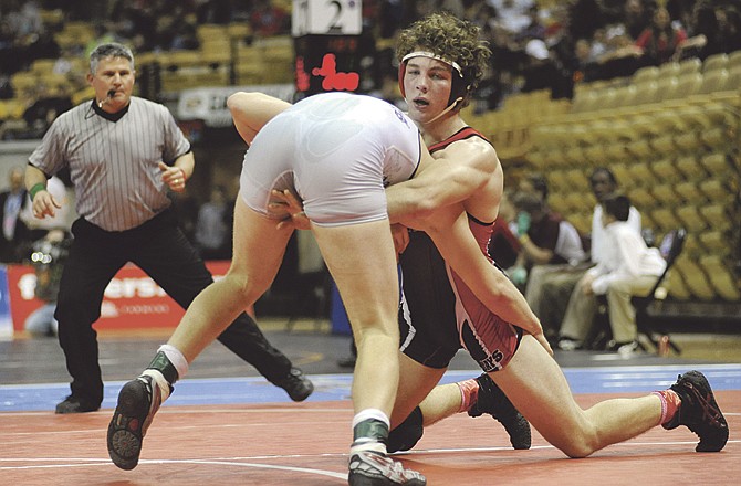 Jefferson City's Jared Johnson (right) leans on Blue Springs' Louis Foutz on Saturday in the Class 4 State Championships at Mizzou Arena. Foutz posted a 9-7 win to take the 189-pound title. 