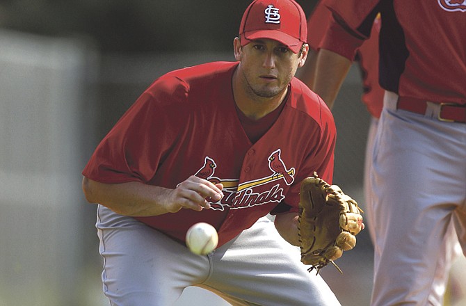 Cardinals third baseman David Freese keeps an eye on a grounder headed his way during a spring training session Sunday in Jupiter, Fla. 