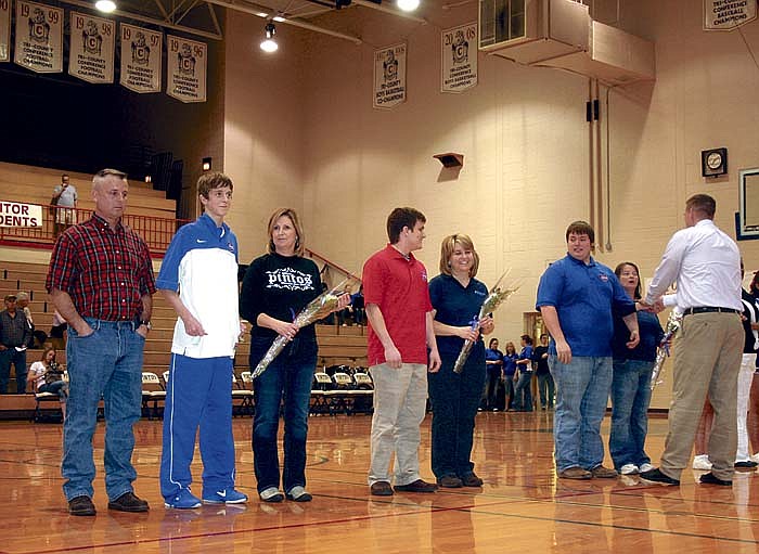 Seniors recognized along with their parents at the Senior Night ceremony at California High School Thursday, from left, are Pinto basketball player Jacob Allison with parents Greg and Paula Allison, senior team manager Jason Woody with mother Christine Hurt, and senior team manager Justin Clad with mother Beth Clad, being congratulated by CHS Head Coach Bobby Sangster.