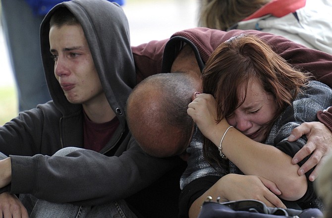 Fifteen-year-old Kent Manning, left, and his sister Lizzy, 18, react Wednesday with their father, who asked not to identified, after they were told by police that there was no hope of finding Kent and Libby's mother alive in a collapsed building following a 6.3-magnitude earthquake Tuesday.