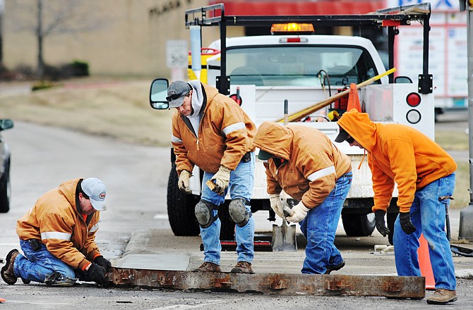 Crews from the Jefferson City Streets Department have been busy this week repairing damage caused by snow-removal equipment hitting street curbs during the recent blizzard. Here, from left, Dennis Kremer, Eric Dulle, Rick Kay and Johnny Braun remove a concrete form after the concrete set up. Curbing at several city and state intersections was damaged and in need of repair. 