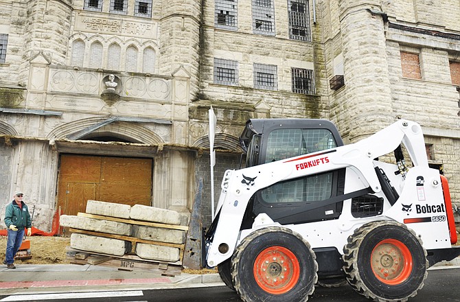 Don Mueller of Mueller Landscaping guides the forklift driver on where to set the pallet of concrete steps as they worked Thursday morning to build a walkway at the entryway of the Missouri State Penitentiary. The work is being done just prior to the start of a new tour season.