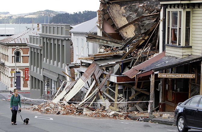 A resident walks a dog Thursday through the center of Lyttelton as she looks at the damage from Tuesday's earthquake, near Christchurch, New Zealand. 