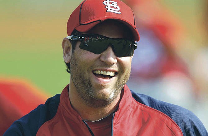 St. Louis Cardinals' Lance Berkman laughs as he stretches with teammates during baseball spring training on Sunday, Feb. 20, 2011, in Jupiter, Fla. 