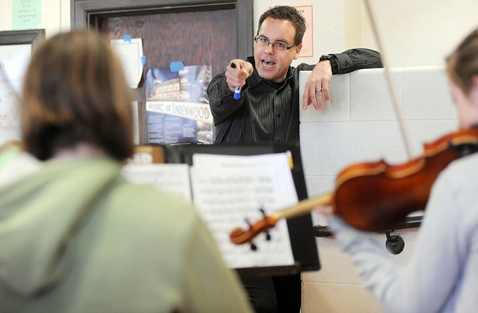 Kirt Mosier determines which violin is coming in too early on a 16th note as ninth-grade orchestra students play a few bars of his composition "Jefferson's Procession" on Monday at Simonsen.