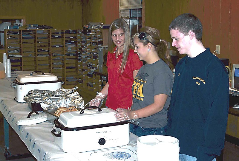 From near right to far left, FFA members Jordan Brizendine, Bailey Glenn and Elle Miller serve pancakes, sausage, biscuits and gravy to teachers, staff and FFA supporters.