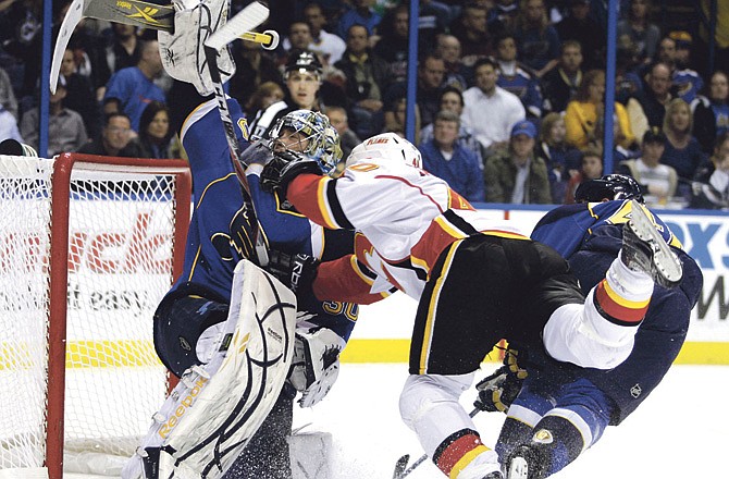 Calgary Flames' Alex Tanguay (40) goes flying into St. Louis Blues goalie Ben Bishop (30) in the first period of an NHL hockey game Tuesday, March 1, 2011 in St. Louis.