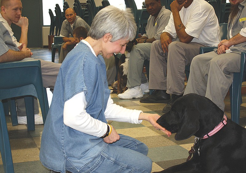 Mandi Steele/FULTON SUN photo: Holts Summit veterinarian Mar Doering rewards Daisy with a treat after the dog obeys the vet's order to "leave it." Doering visits Jefferson City Correctional Center every other week to help inmates in the Puppies for Parole program with behavioral dog training. 