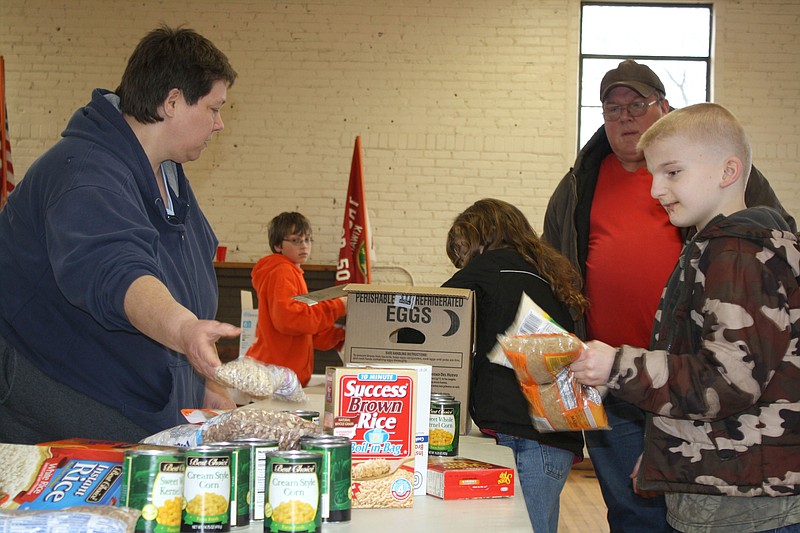 Katherine Cummins/FULTON SUN photo: (From left) Mom Janice Gillispie, Scout Andy Lindner, 10, Shelby Loftus, 8, father Kurt Lindner and Timothy Loftus, 11, sort food Saturday at the Scout Cabin.