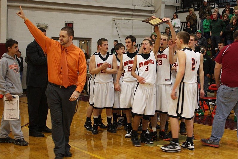 Contributed photo: New Bloomfield head coach Tyler Clark recognizes the Wildcats' fans with a raised index finger while his players celebrate with the championship plaque after No. 5 seed New Bloomfield turned back No. 2 Silex 58-52 for the District 5 title on Saturday night at Louisiana High School. The Wildcats (11-16) face Canton (19-6) in a Class 2 sectional at Hannibal High School at 6 tonight.
