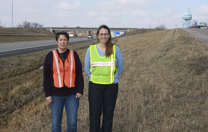 Denise Oxley, right, chairman of the 54 Ramp Beautification Committee, and Pamela Murray, president of the Holts Summit Community Betterment Association, stand at the southeast Center Street exit ramp in Holts Summit, which will be the first of six U.S. 54 ramps the organizations will beautify this spring.